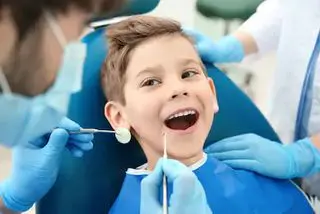 Child Smiling Sitting in a dental chair